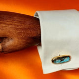 Bronze sculptural oblong cufflink with blue detail.